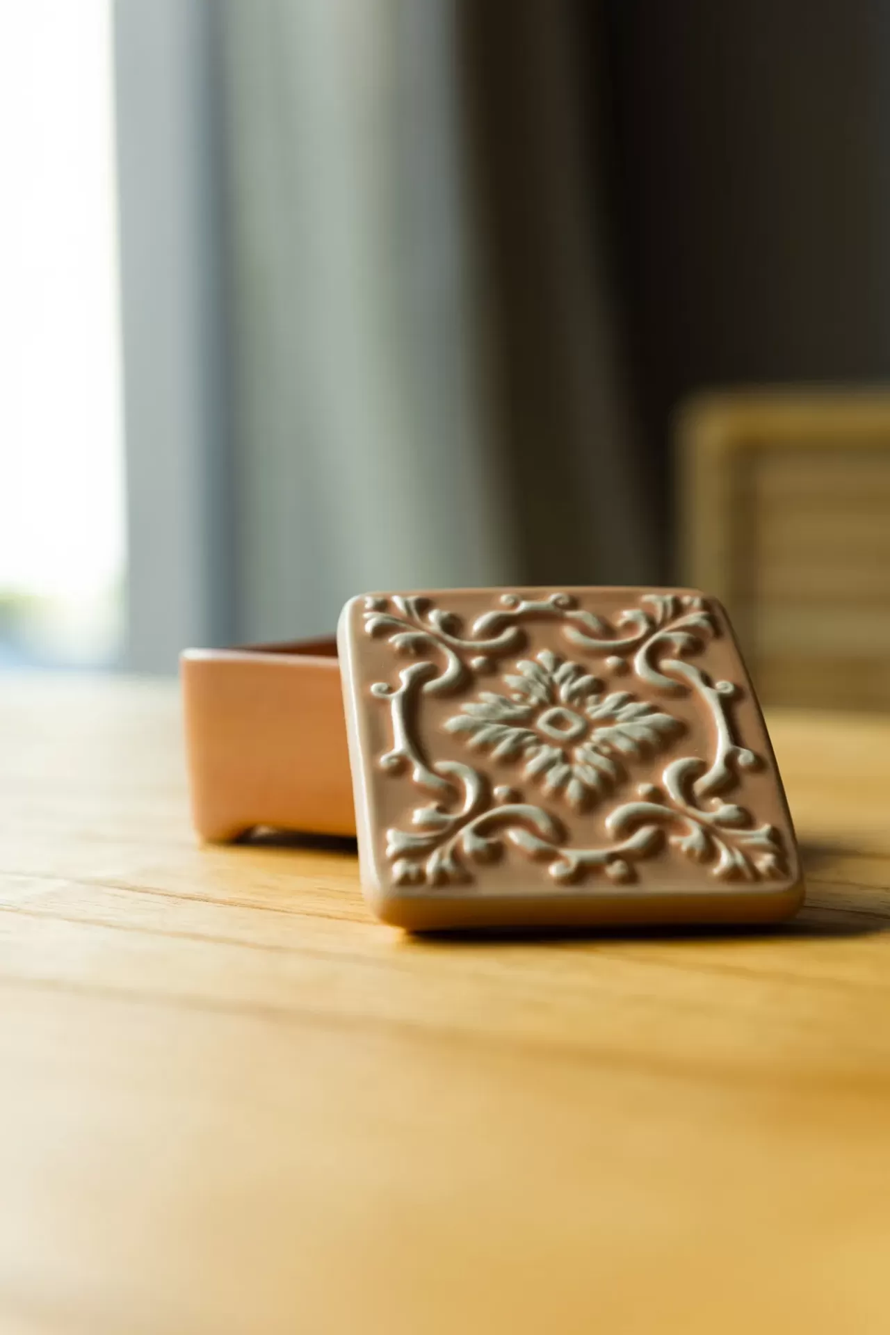Caixa decorativa de cerâmica rosa claro com padrão floral em relevo
