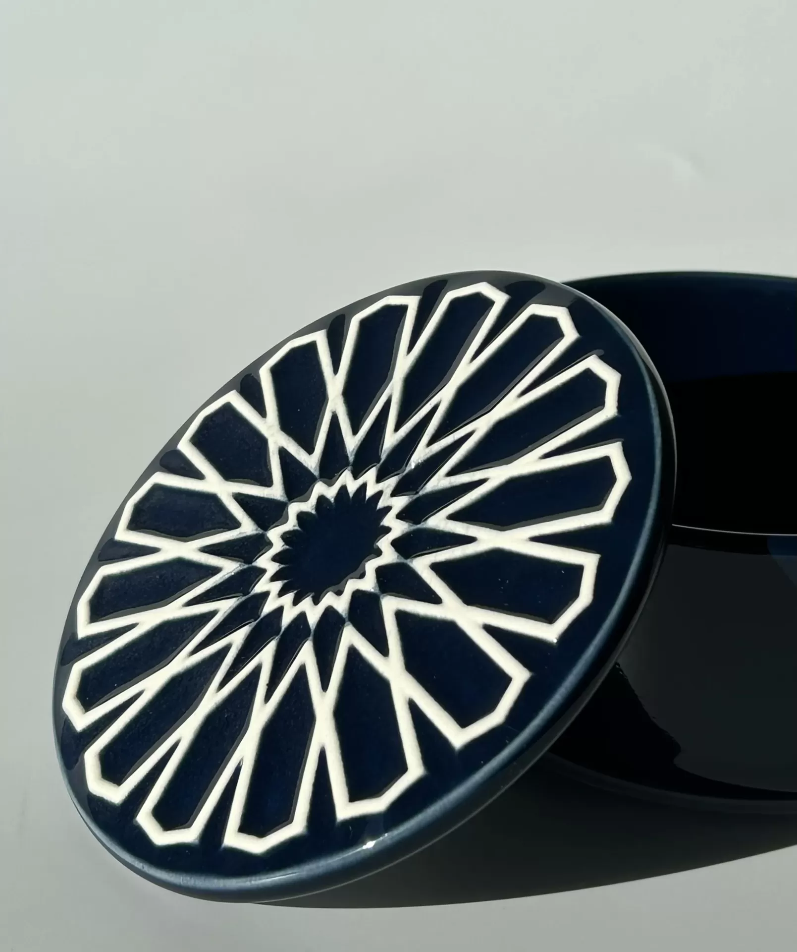 Tampa cerâmica azul escura com padrão branco em relevo