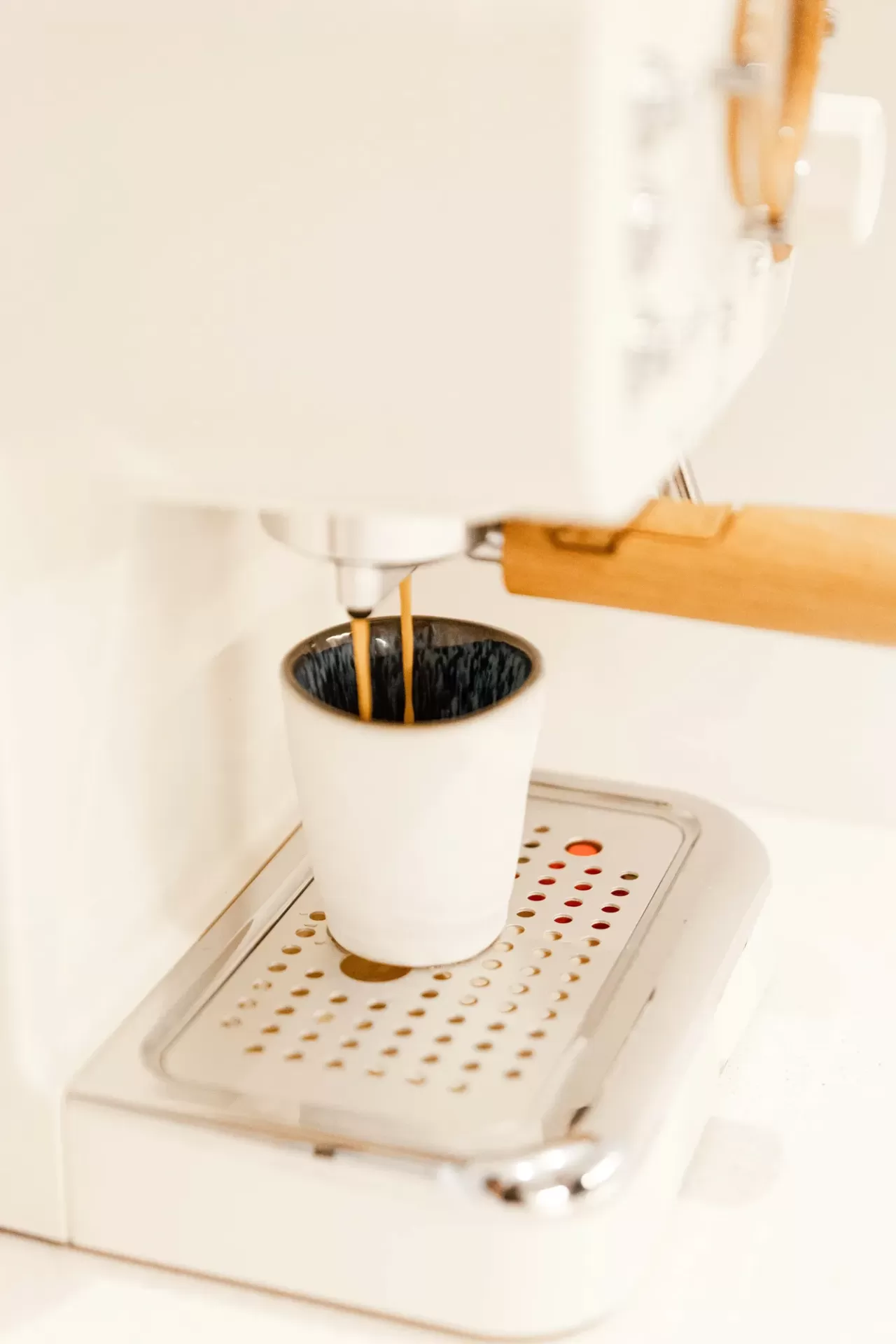 Máquina de café branca com chávena a receber café