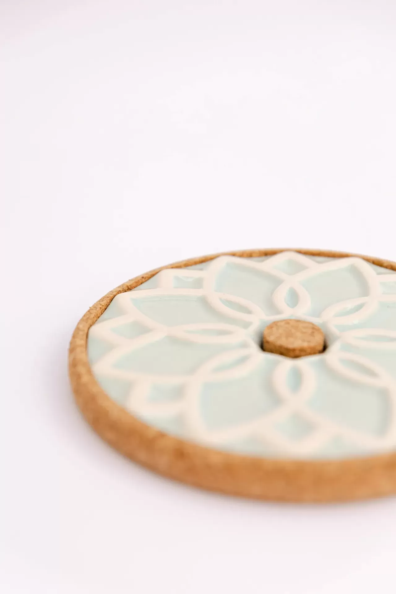 Base redonda de cortiça e azulejo cerâmico com padrão floral geométrico