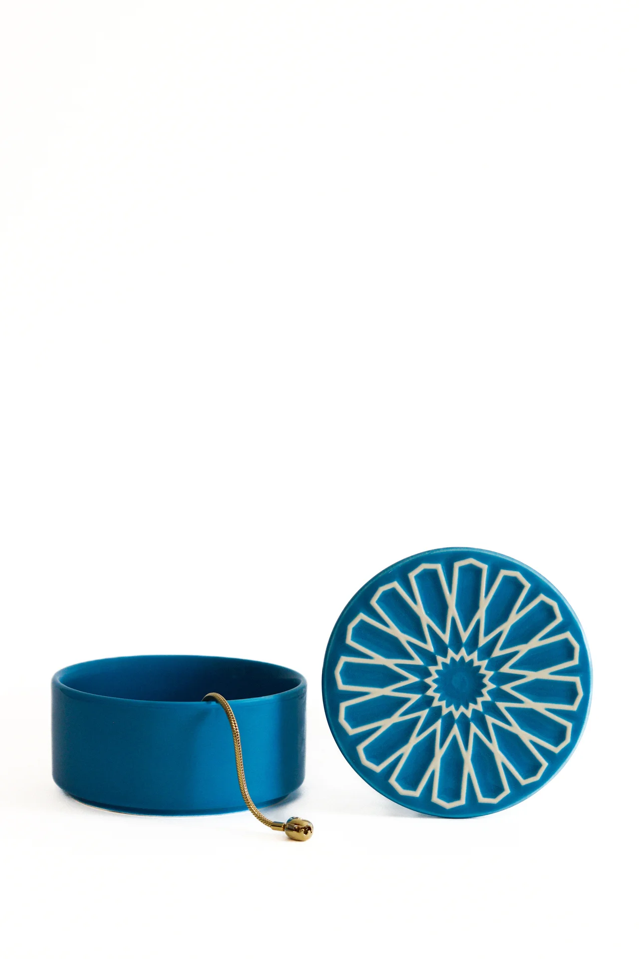 Caixa redonda azul com tampa decorada com padrão geométrico branco