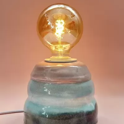 Lâmpada de mesa em cerâmica azul com lâmpada LED ligadda