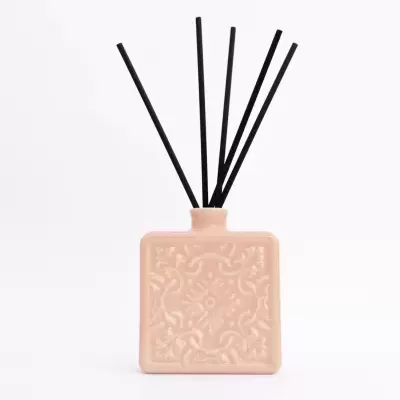 Difusor de aromas rosa claro com padrão em relevo e varetas pretas