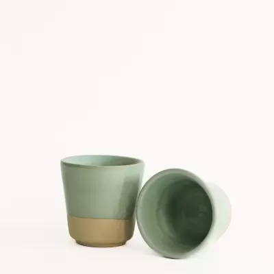 Dois copos cerâmicos verde claro com base castanha em fundo branco