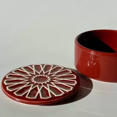 Caixa redonda de cerâmica vermelha com tampa decorativa e interior preto