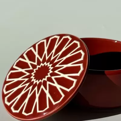 Frasco de cerâmica vermelha com tampa decorada com padrão geométrico branco