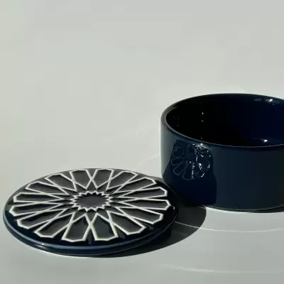 Caixa redonda azul escuro em cerâmica com tampa decorada em padrão geométrico