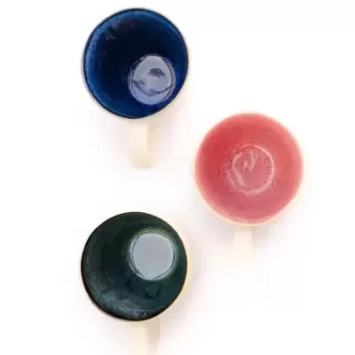 Três chávenas de chá coloridas vistas de cima.