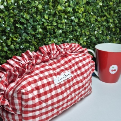 Bolsa xadrez vermelha e branca matelassada com babados e caneca vermelha com estampa de cerejas