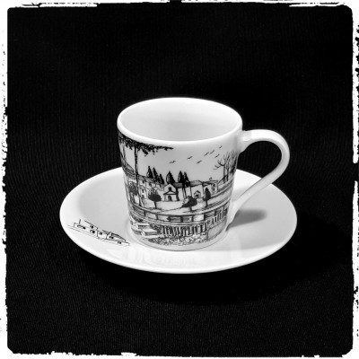 chávana de porcelana branca com desenhos a preto em pires branco sobre fundo preto