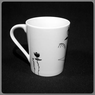 Caneca branca em cerâmica com decoração preta de plantas e árvore