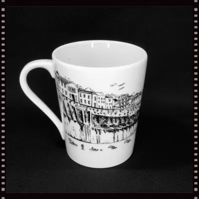 Caneca de porcelana branca com ilustração a traço preto do casario típico da Ericeira