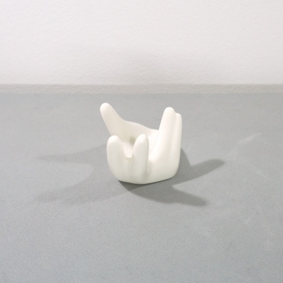 Escultura decorativa branca em cerâmica sobre fundo cinza