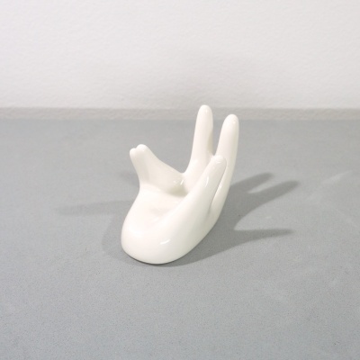 Escultura branca brilhante de mão em cerâmica com dedos levantados