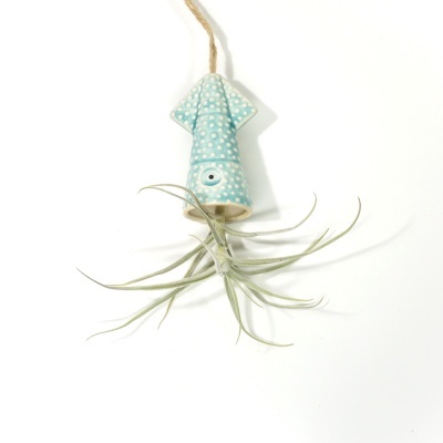 Suspensão decorativa em cerâmica azul com padrão de bolinhas brancas em forma de lula com planta