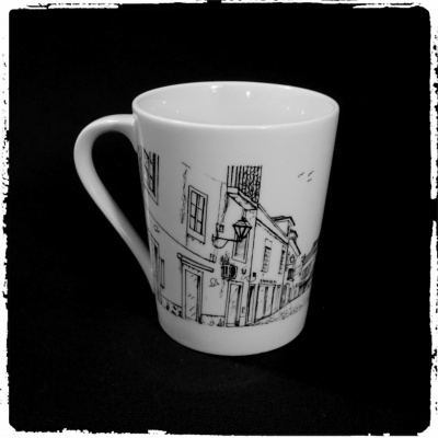 Caneca branca com ilustração de edifícios em fundo preto