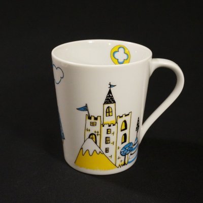 Caneca branca com desenho de castelo, montanha e árvores coloridas
