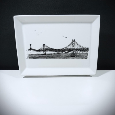 Prato retangular branco com desenho preto de ponte suspensa e monumento
