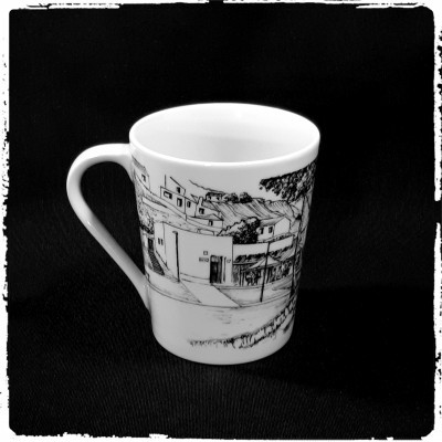 Caneca branca com desenho monocromático de edifícios