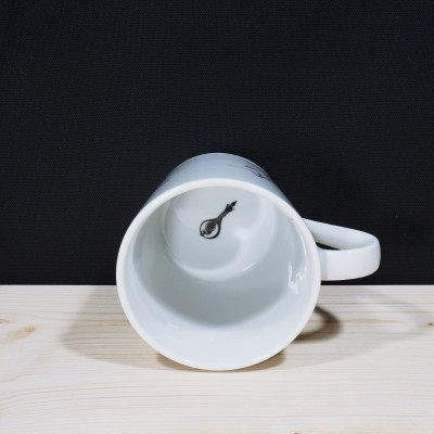 Caneca branca de cerâmica mostrada deitada com chave desenhada no interior