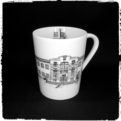 Caneca branca de cerâmica com desenho preto de fachada de edifício clássico