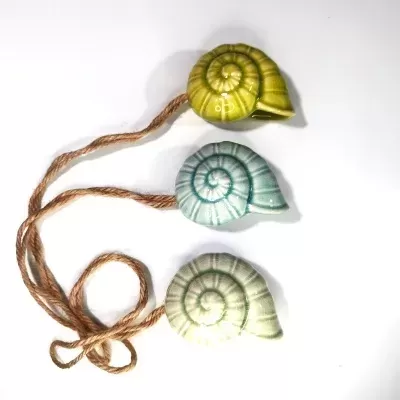 Suportes suspensos de cerâmica em forma de caracol, nas cores verde, azul e bege, com cordas de juta
