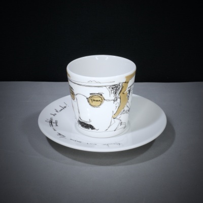 chávena e prato de porcelana decorados em branco, dourado e preto