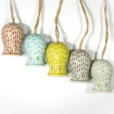 Cinco sinos decorativos em cerâmica coloridos e pendurados com cordas