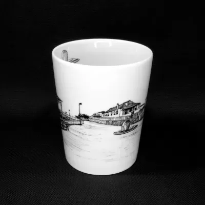 Caneca de porcelana branca sem pega visível, exibindo uma ilustração detalhada a preto do casario