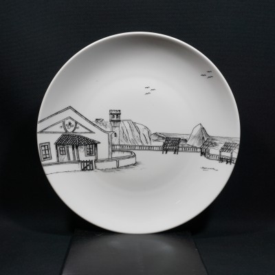 Prato branco de cerâmica com ilustração preta de edifícios e paisagem
