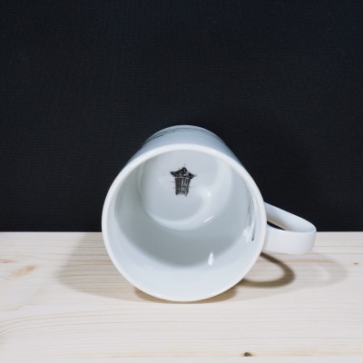 Caneca branca de cerâmica vista de lado com desenho preto no interior