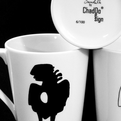 Canecas brancas de cerâmica com desenhos abstratos pretos e texto no fundo
