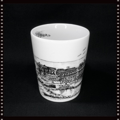 Copo de cerâmica branco com desenho preto de edifício e natureza
