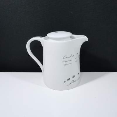 Bule de cerâmica branco com texto manuscrito e desenhos de pegadas