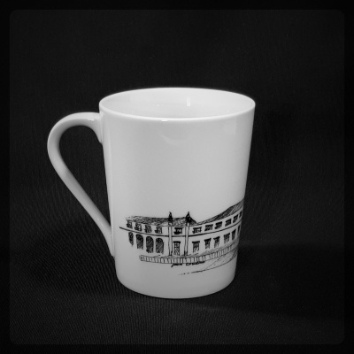 Caneca branca com ilustração a preto de fachada de edifício