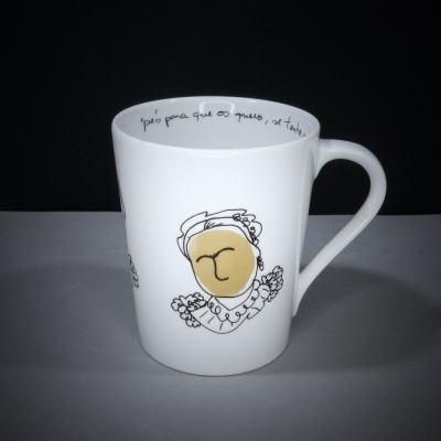 Caneca branca com ilustração de rosto estilizado e texto manuscrito no interior da borda