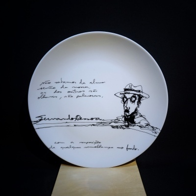 Prato cerâmico branco com desenho e texto manuscrito preto de Fernando Pessoa