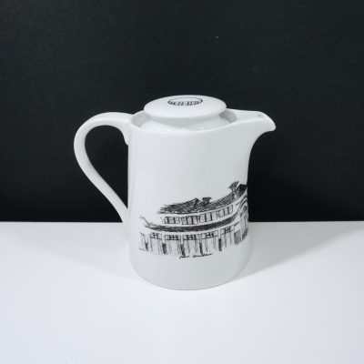 Bule branco de cerâmica com desenho a preto de edifício