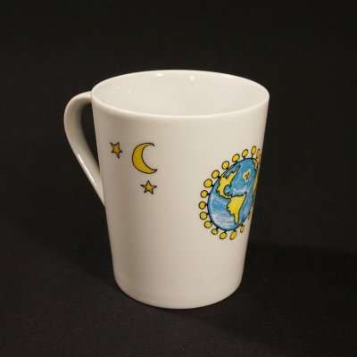 Caneca branca com desenhos do planeta Terra, lua e estrelas