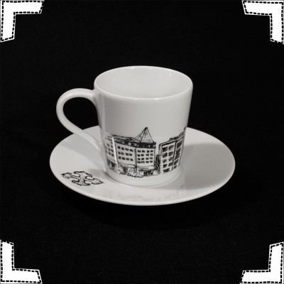Chávena e pires de porcelana branca com desenho preto de edifícios urbanos