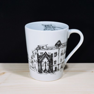 Caneca branca de cerâmica com desenho preto de edifícios