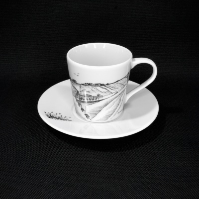 Conjunto de chávena e prato em porcelana branca com desenho monocromático de paisagem rural