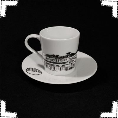 Conjunto de chávena e prato de porcelana branca com desenho de edifício em preto