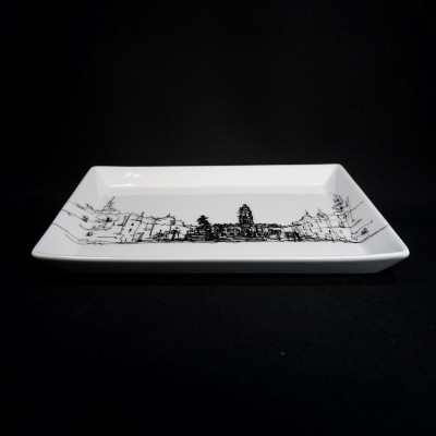 Prato retangular branco com desenho preto de cidade sobre fundo preto