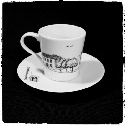 Chávena de café branca com desenho preto e pires com desenho