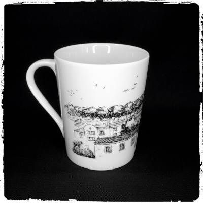 Caneca branca com desenho preto de casas e árvores