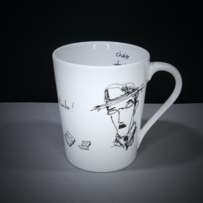Caneca branca com desenho a tinta preta de rosto masculino e textos manuscritos