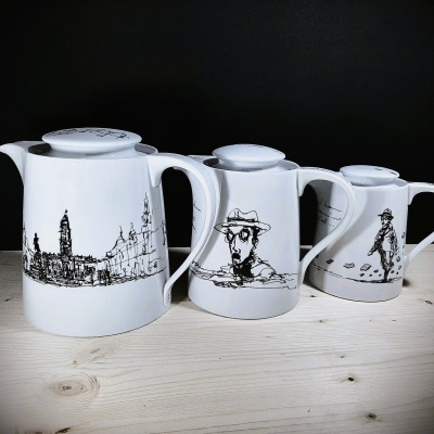 Conjunto de três bules cerâmicos brancos com desenhos pretos