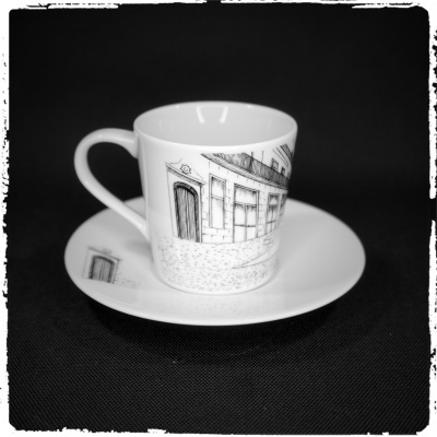 Conjunto de chávena e pires branco com desenhos de edifícios em preto
