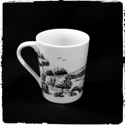 Caneca branca com desenho preto de paisagem rural